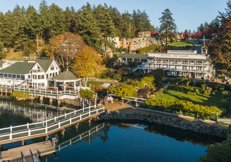 Sky view of a hotel building and harbor, with a large garden in between the two