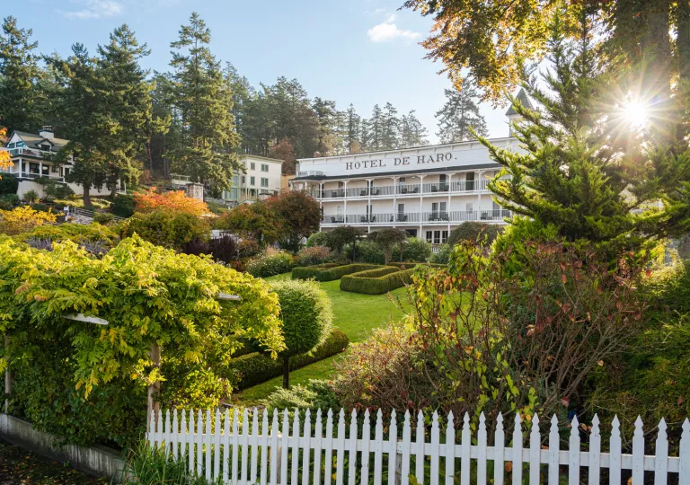 Hotel exterior, with a garden and white picket fence in front