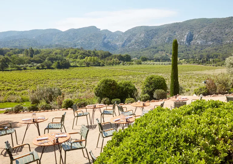 Outdoor dining area with a large grass valley in the background