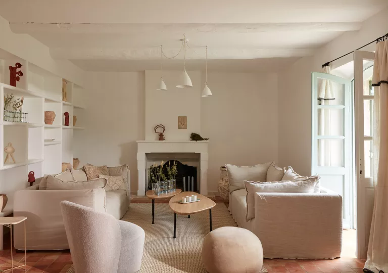 Indoor lounge with cushioned chairs with an open door on the right
