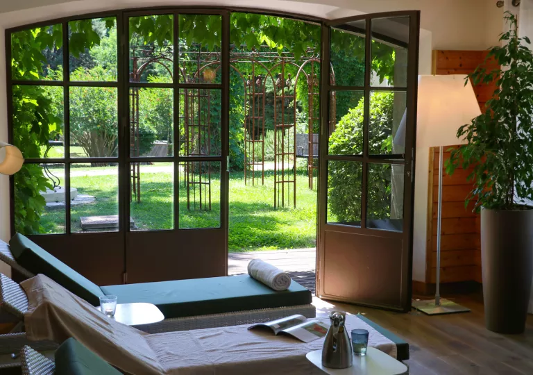 lounge chairs next to french doors opening into a garden