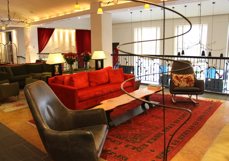 red couch and leather chairs in hotel living room