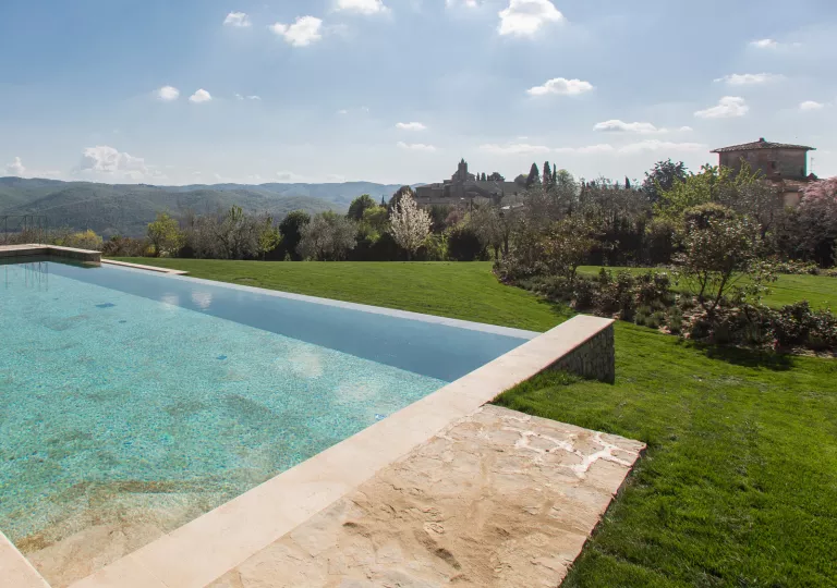Outdoor infinity pool on a grassy hill, looking out to an open valley