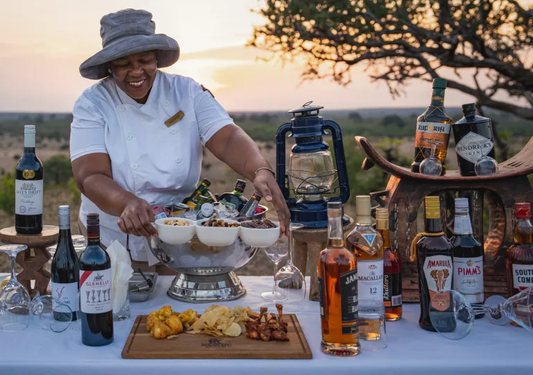 Woman preparing a table full of alcohol and snacks