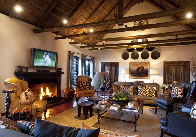 Hotel lobby with a television over a fire place, surrounded by cushioned couches