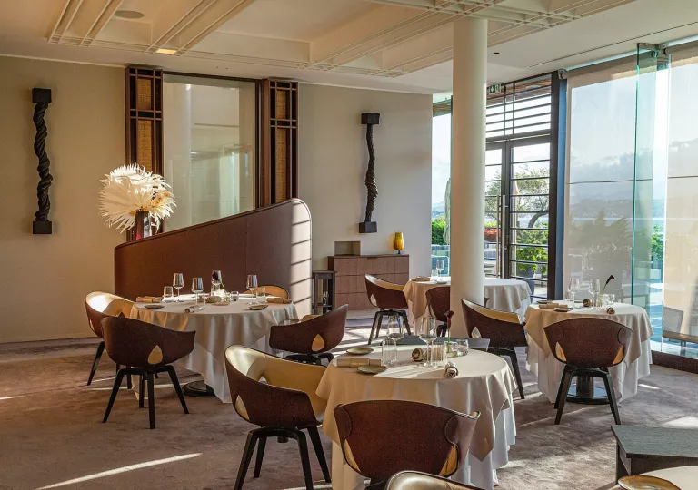 Dining area with brown and white chairs surrounding circular dining tables