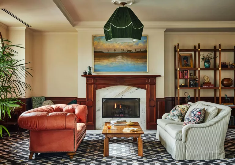 Stone and wood fireplace, with two red and white cushioned sofas in front