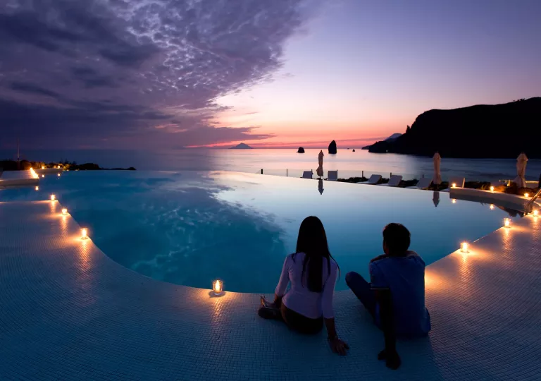 candlelit hotel pool overlooking sunset