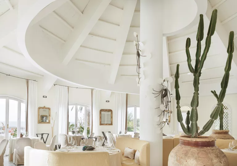 Dome-shaped room with a white pillar and chairs around each table
