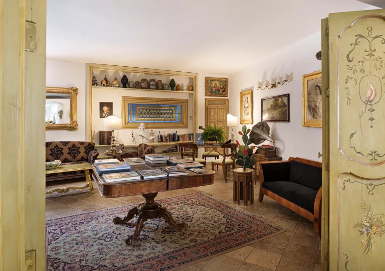 Library room with a big, square table and cushioned sofas