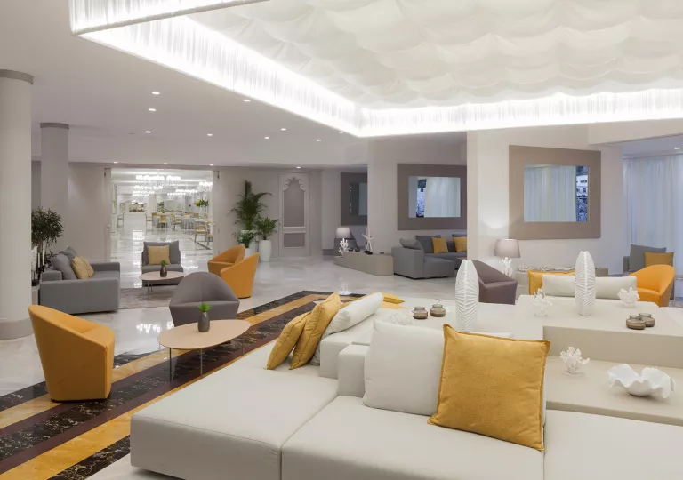 Indoor hotel lobby with a white cushioned couch in the center