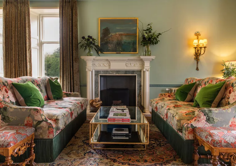 couches with flower print next to fireplace