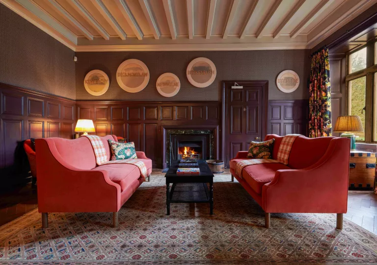 red couches in wood paneled room