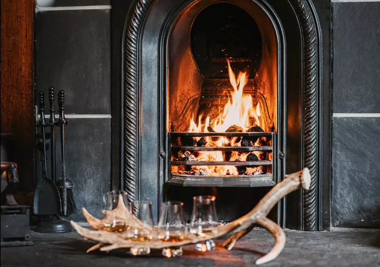 Black stone fireplace with wine glasses on a table in front
