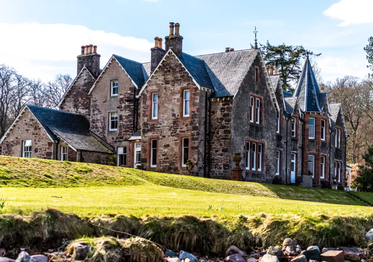 Rustic, brown brick building with an open grass area in front