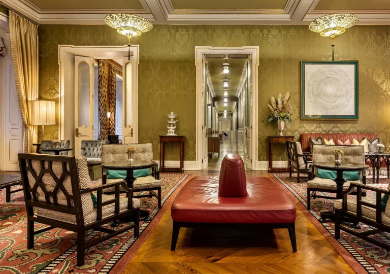 Large lobby with a long hallway in the background, and a red leather sofa in the center