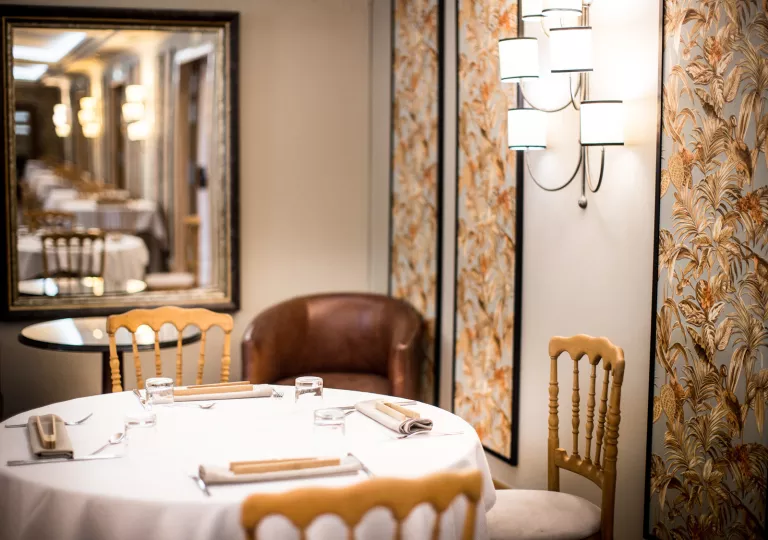 Dining table with wooden chairs and leather seats surrounding it