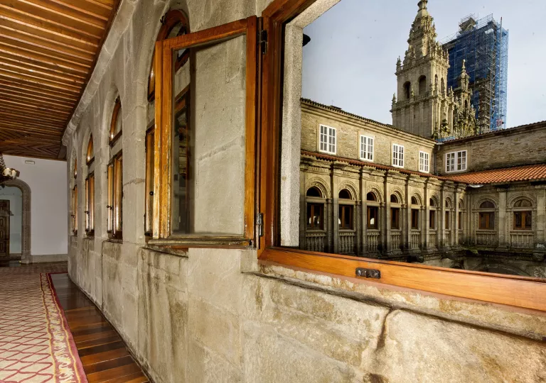 Stone walls with open windows looking out to castle-like buildings