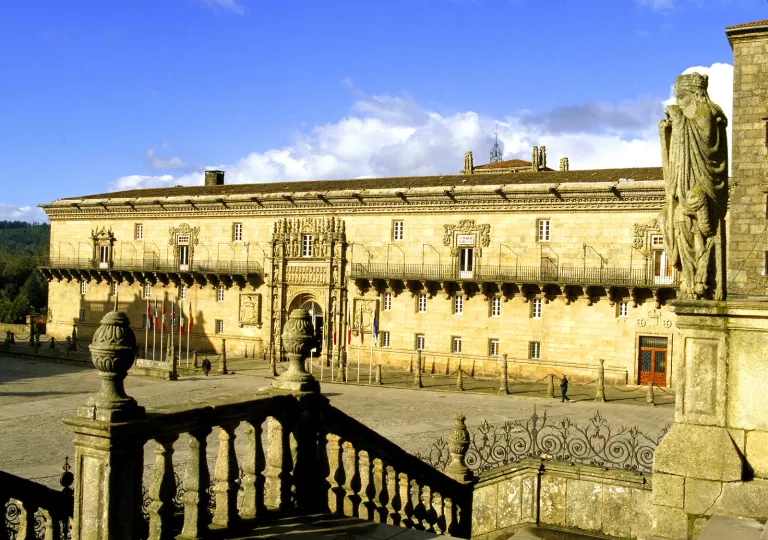 Rustic, Spanish-style building with a statue in a large courtyard