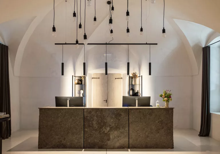 Front desk concierge area with two computers and dangling lights