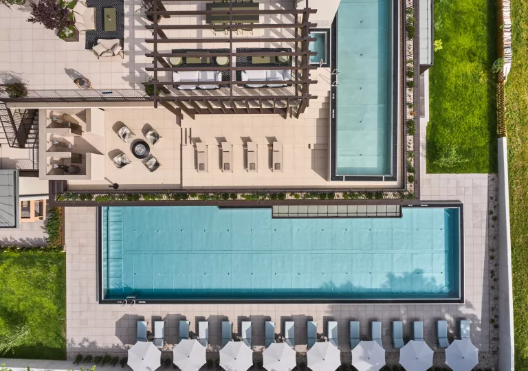 Sky view of outdoor pool, surrounded by chairs and umbrellas
