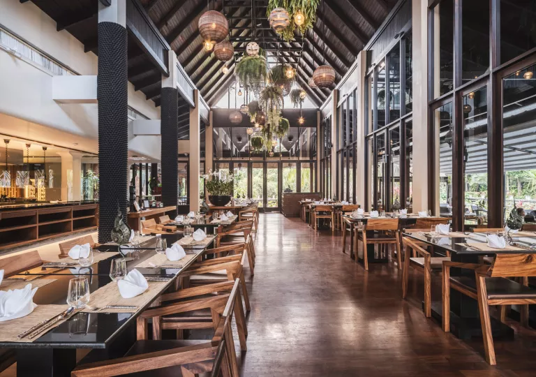 Indoor dining hall with wooden chairs and large windows on the walls