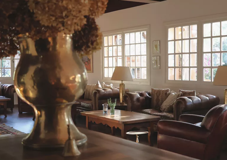 Indoor lounge with copper vases and brown cushioned sofas