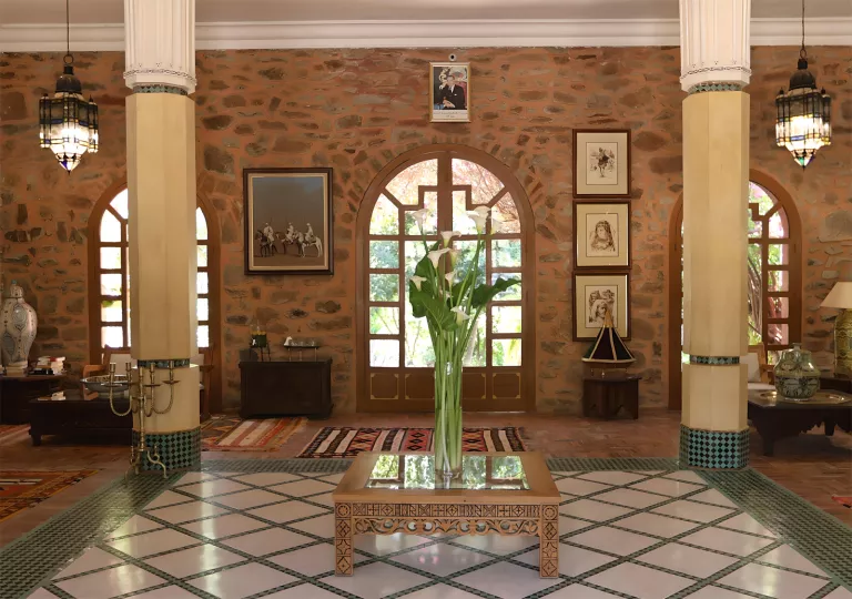Indoor lobby with a vase full of plants in the center and two large pillars on either side
