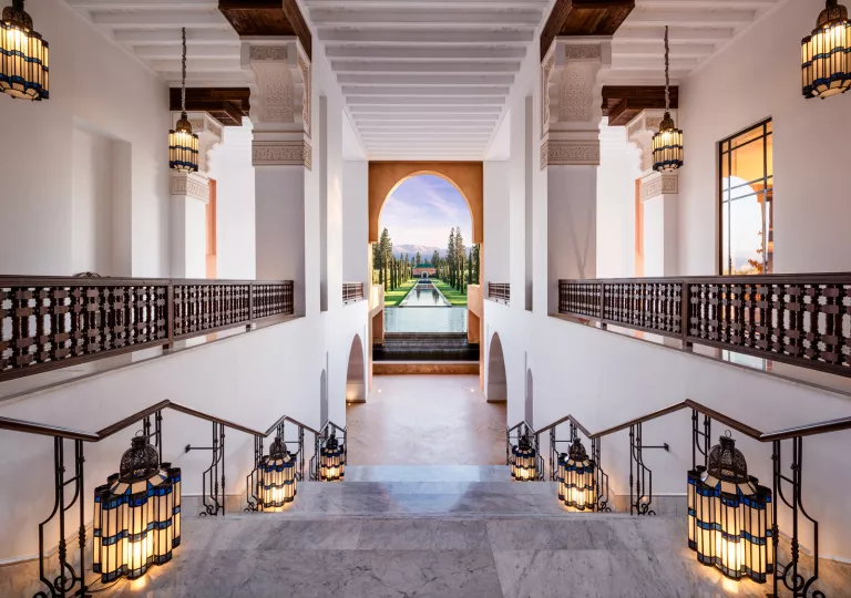 Indoor staircase with marble floors and chandeliers