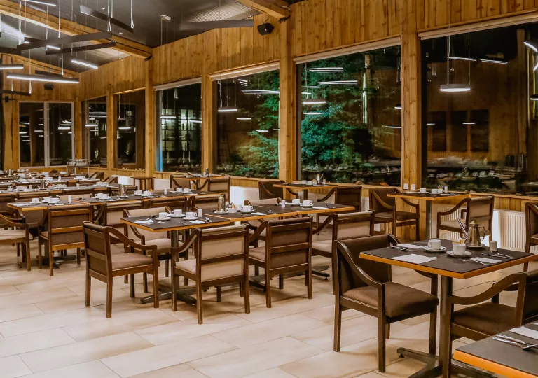 Indoor cabin dining hall with brown cushioned chairs and brown tables