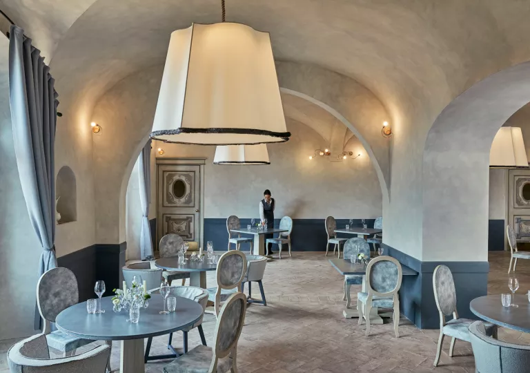 Dining area with large stone walls, and blue and gray tables and chairs