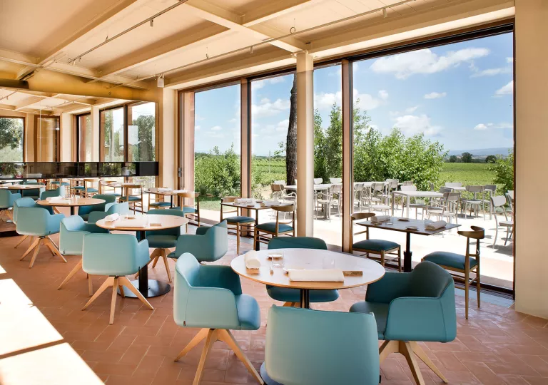 Dining hall with blue cushioned chairs and large windows