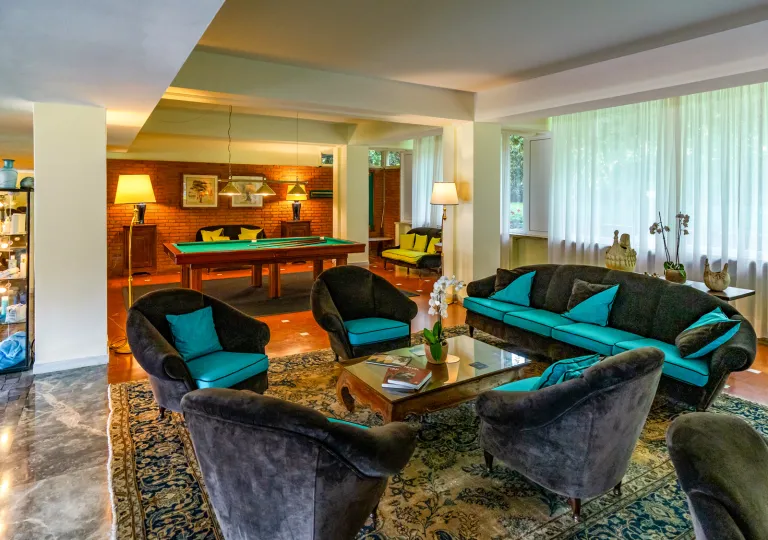 Lounge with gray and blue sofas and a billiards table in the background