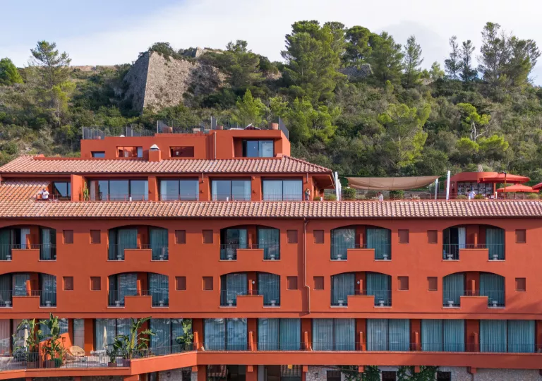 Red hotel building with individual balconies per room