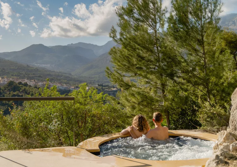 Two people in a hot tub overlooking a canyon
