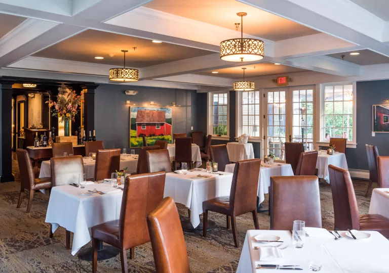 Indoor dining hall with brown, leather chairs and white tables