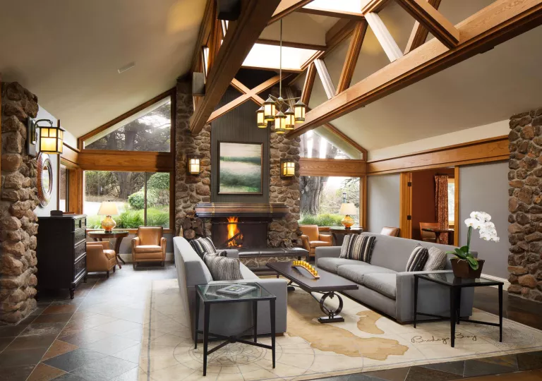 Indoor lobby with stone pillars and a fireplace in the center