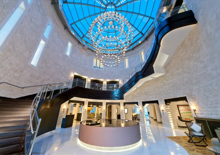 Hotel indoor foyer with large chandelier and circular staircase