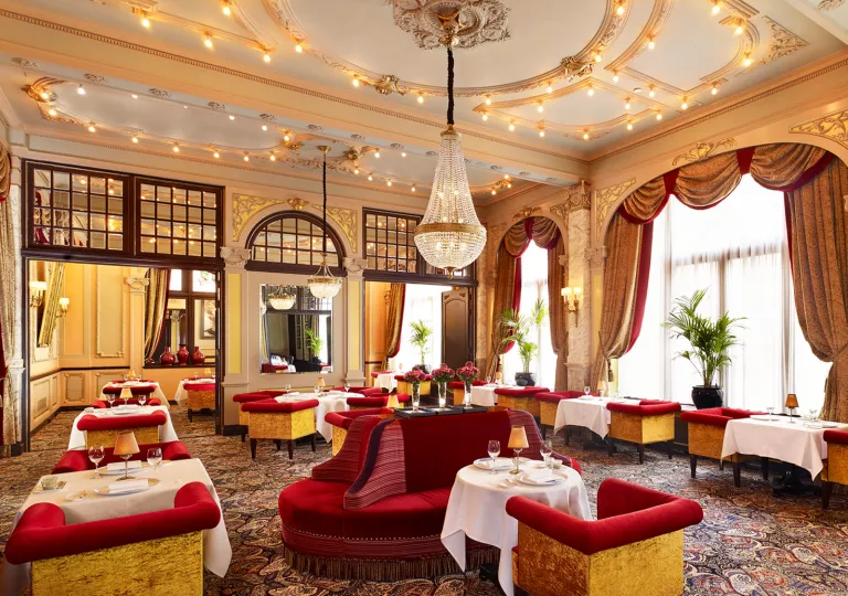 Dining room with red couches and white curtains