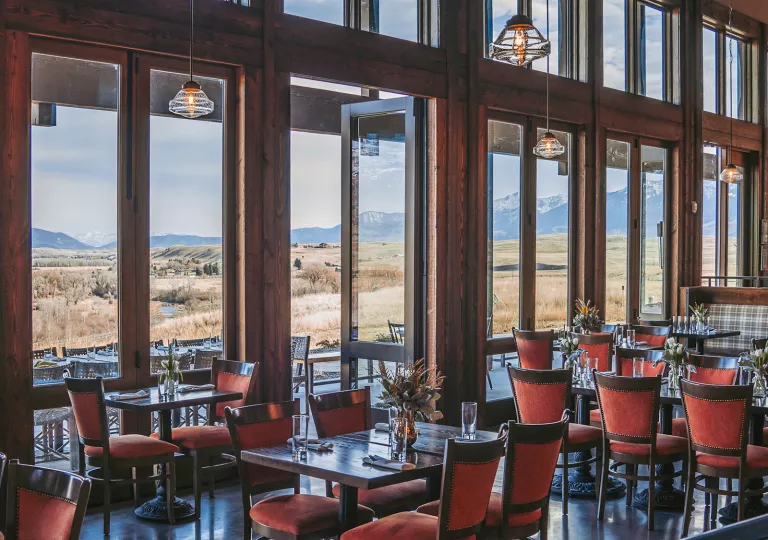 dining rooms with large windows opening up to a view