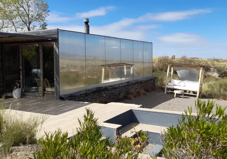 Building with mirror walls in the middle of a valley of plants