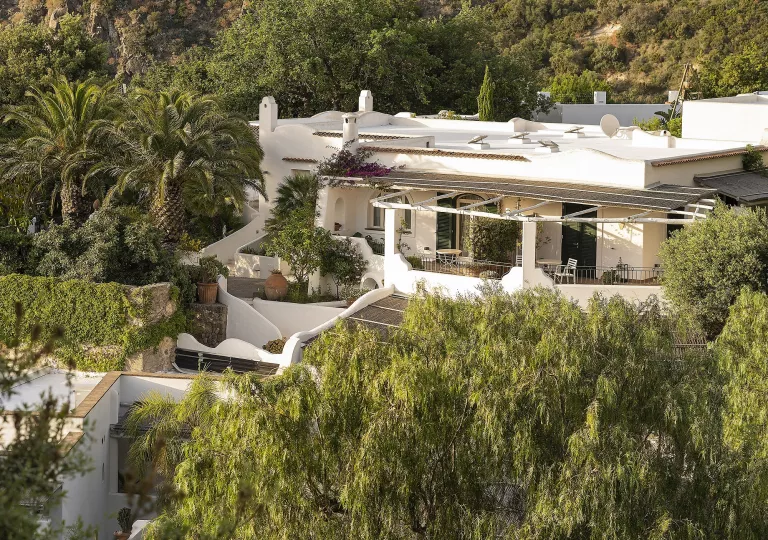 Hotel exterior of a white building surrounded by trees
