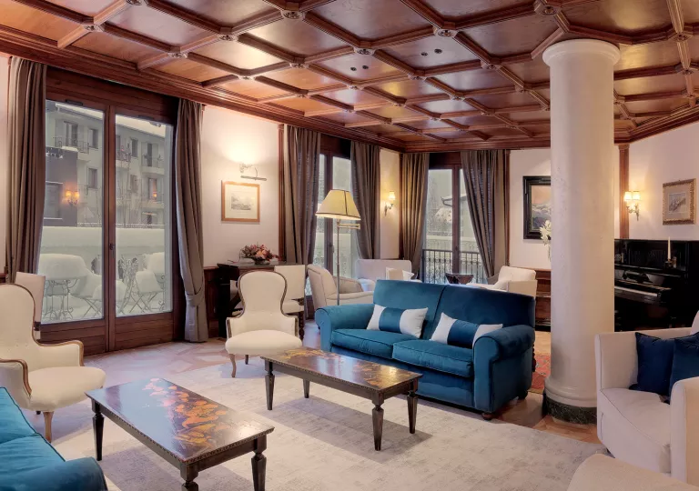 Indoor hotel lounge with blue and white cushioned chairs and white pillars