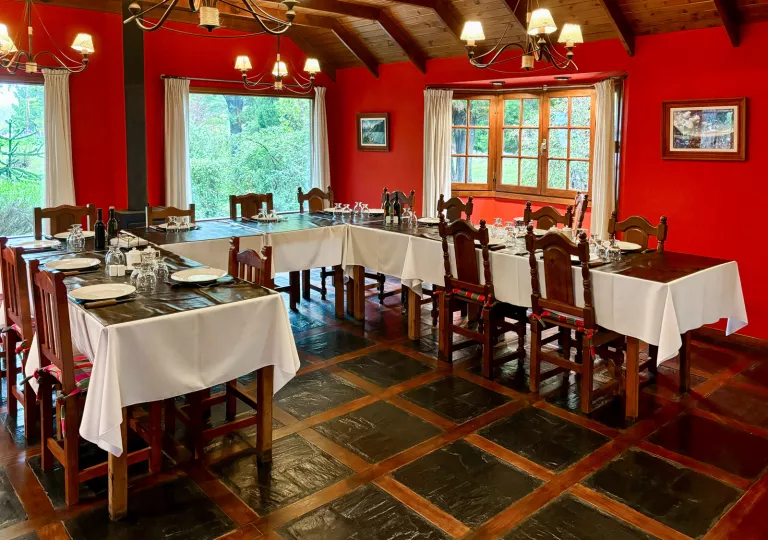 Dining hall with tables shaped in a half circle, with bright red walls