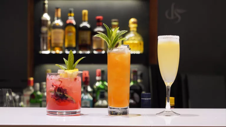 Three colorful alcoholic beverage on a bar counter