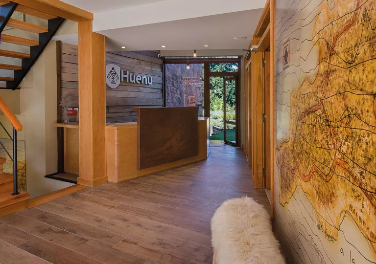 Hotel front desk with a wooden counter and a map on the wall