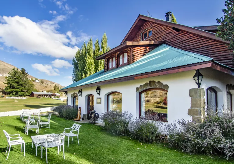 Cabin building with a green roof, and large grass field in front