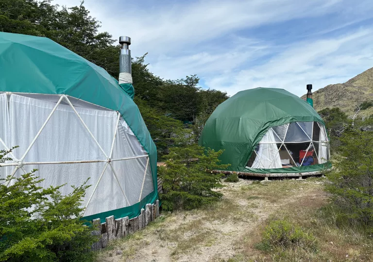 Small dome huts next to each other with a valley in the background