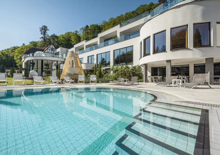 Outdoor pool in front of a long, white hotel building