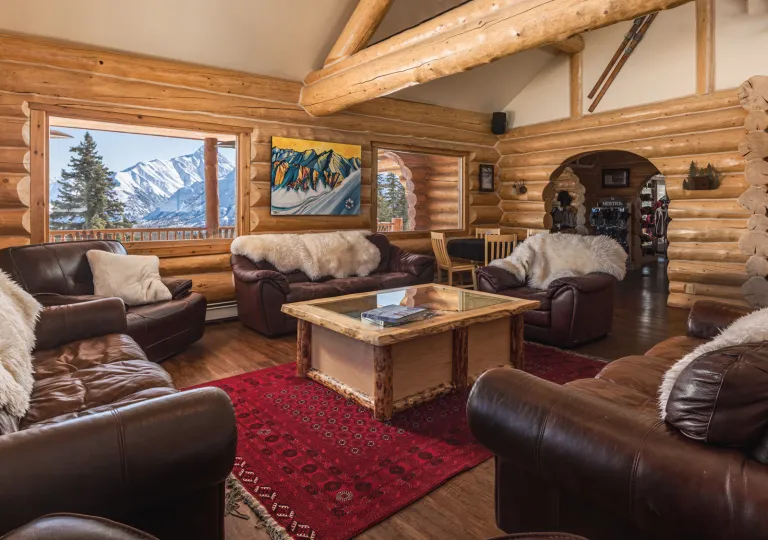 Leather chairs in a cabin with fur blankets on each sofa